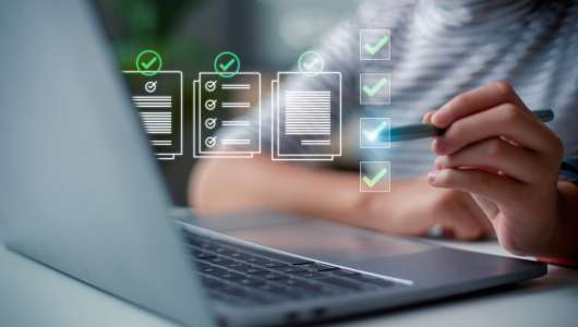 Mulher utilizando notebook e realizando um checklist